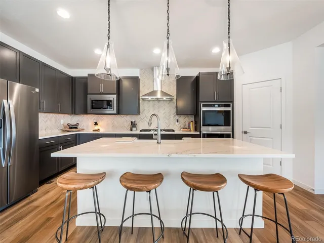 a kitchen with stainless steel appliances kitchen island a refrigerator and microwave