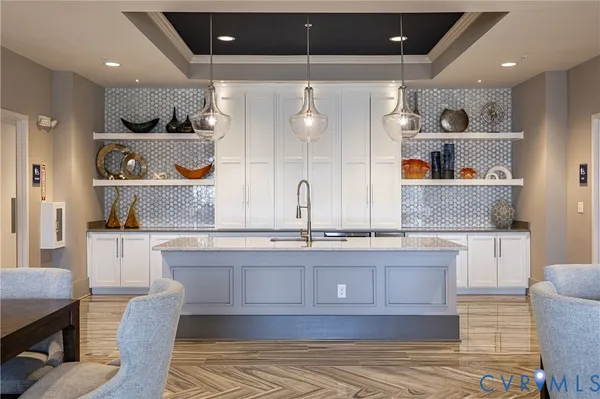 a large kitchen with stainless steel appliances a large counter top a stove and a chandelier