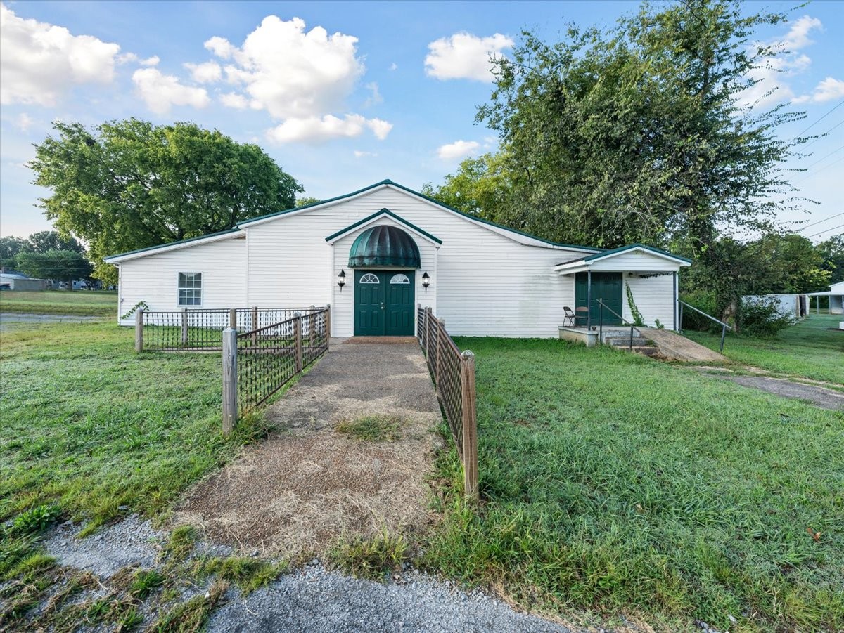 a front view of a house with yard and green space