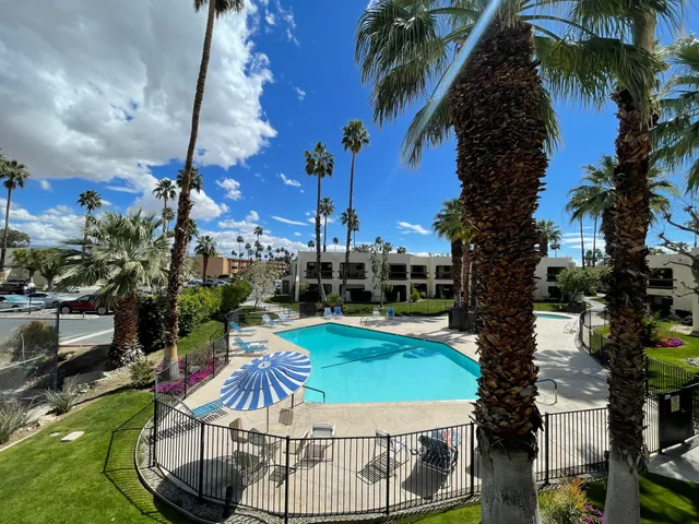 a view of a swimming pool with a patio and a fire pit