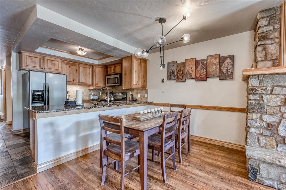 200 North Ridge Street, Unit R A Breckenridge, CO 80424 - Photo 16 of 38 a kitchen with stainless steel appliances granite countertop a table chairs refrigerator and microwave