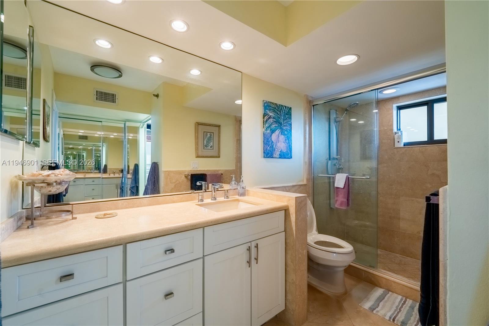 100 Ocean Trail Way, Unit 408 Jupiter, FL 33477 - Photo 16 of 46 a spacious bathroom with a toilet sink double vanity and mirror