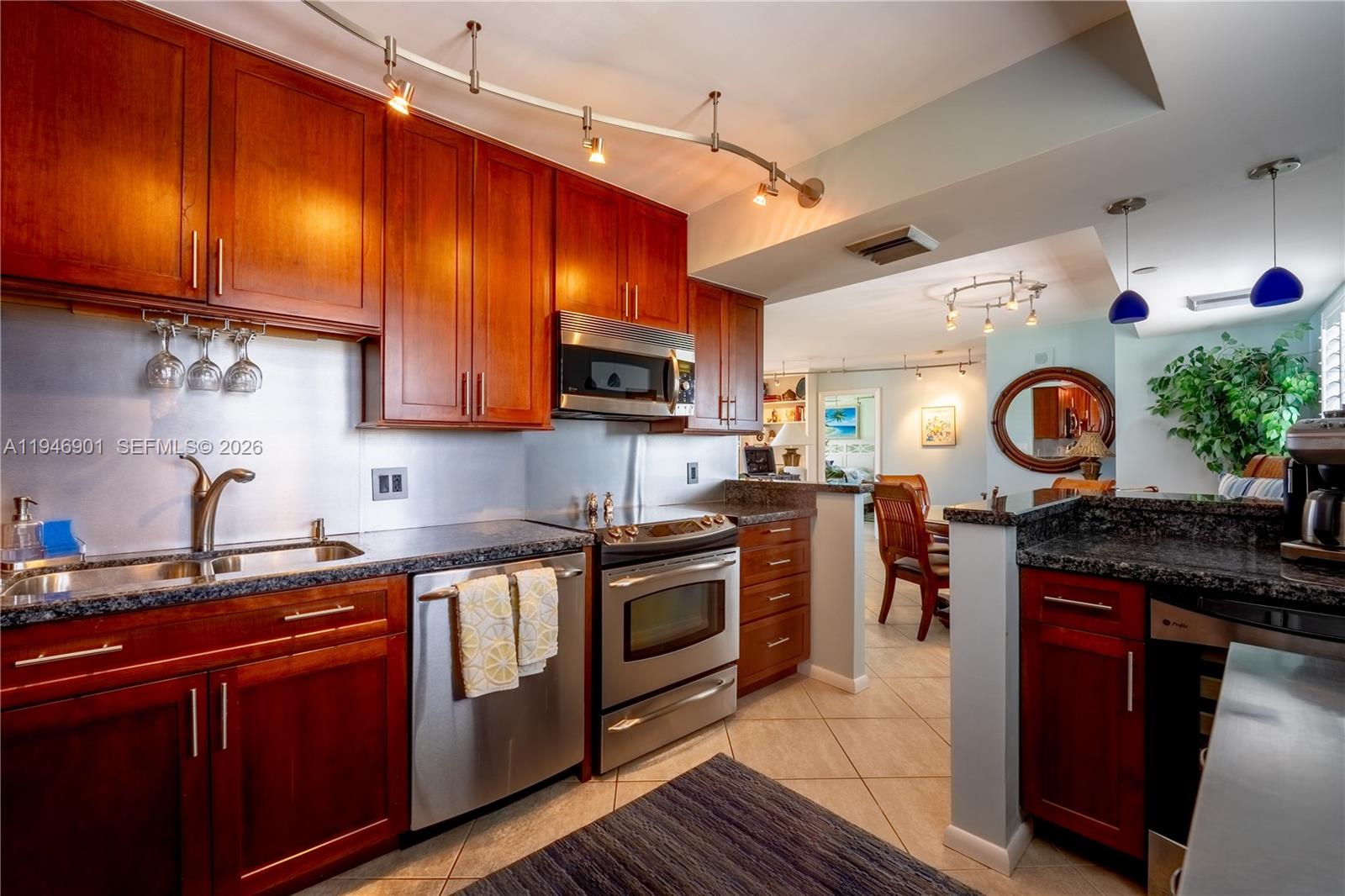 100 Ocean Trail Way, Unit 408 Jupiter, FL 33477 - Photo 26 of 46 a kitchen with stainless steel appliances granite countertop a stove a sink dishwasher and a microwave oven with cabinets