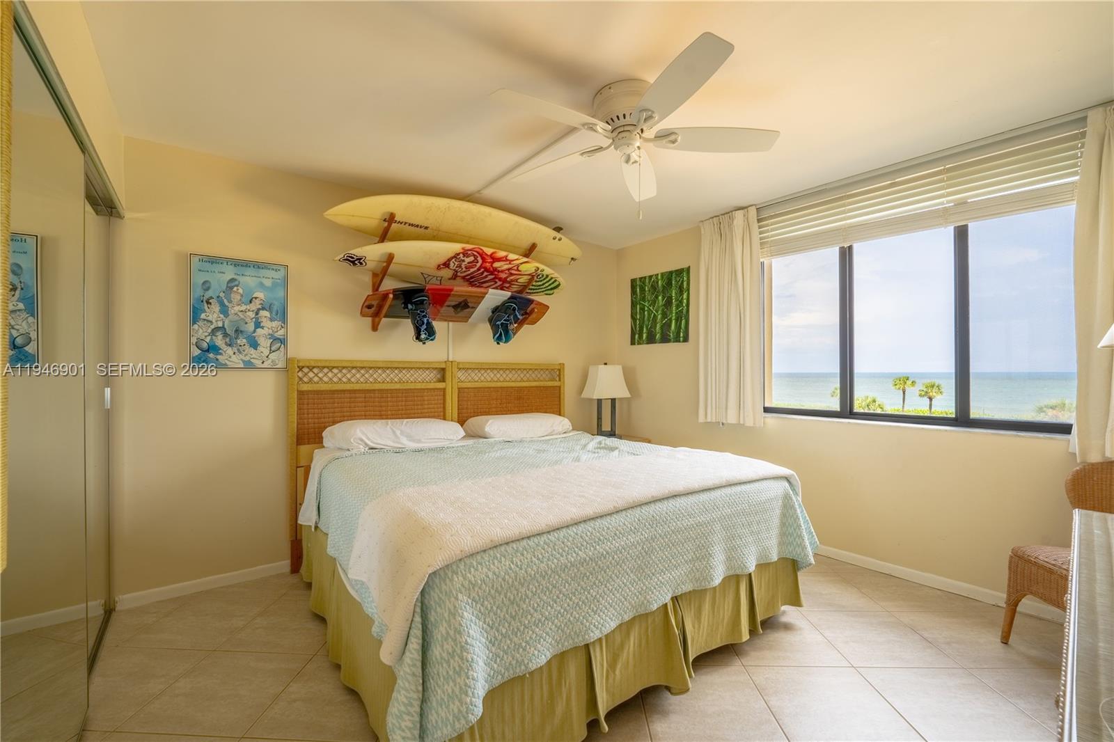 100 Ocean Trail Way, Unit 408 Jupiter, FL 33477 - Photo 37 of 46 a bedroom with a bed and a chandelier