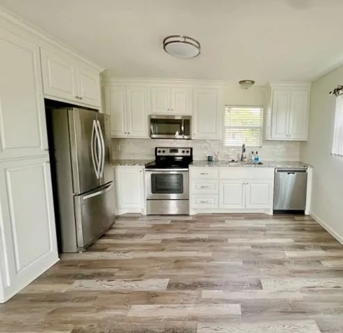 a kitchen with stainless steel appliances granite countertop a refrigerator stove and sink