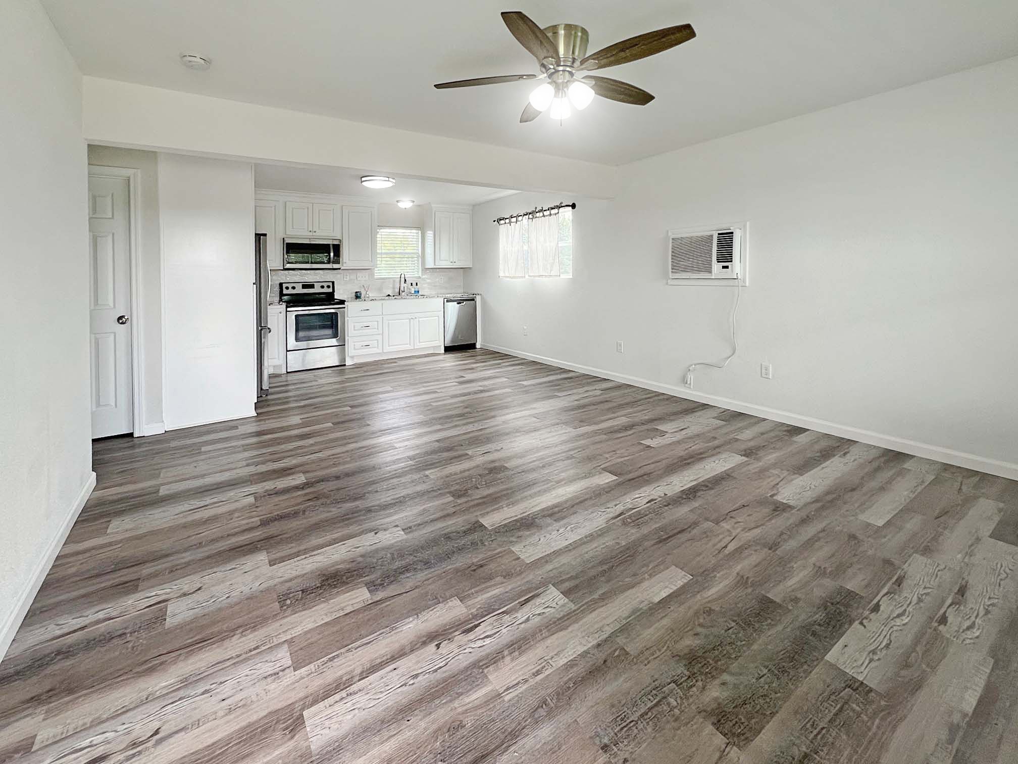 1855 Campbell Road Winnie, TX 77665 - Photo 4 of 11 a view of empty room with wooden floor and window