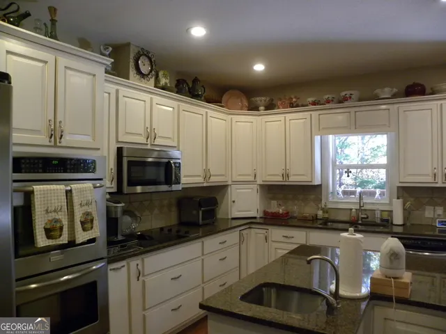 a bedroom with a bed and a flat tv screen on dresser