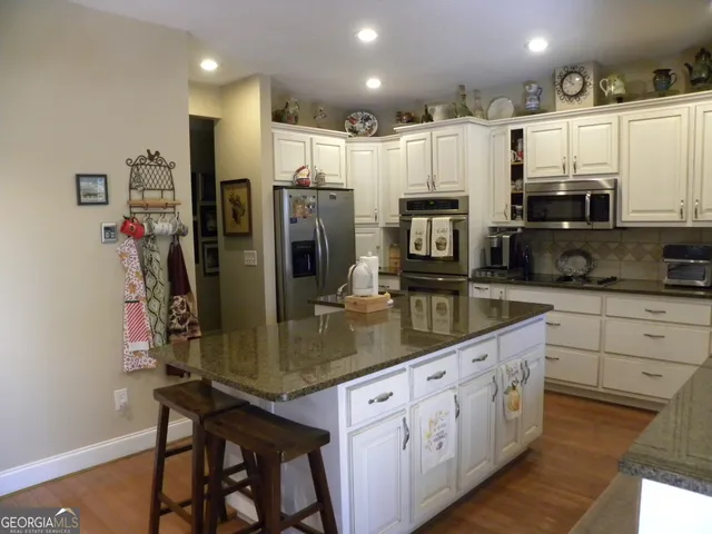 a kitchen with granite countertop a sink window and cabinets