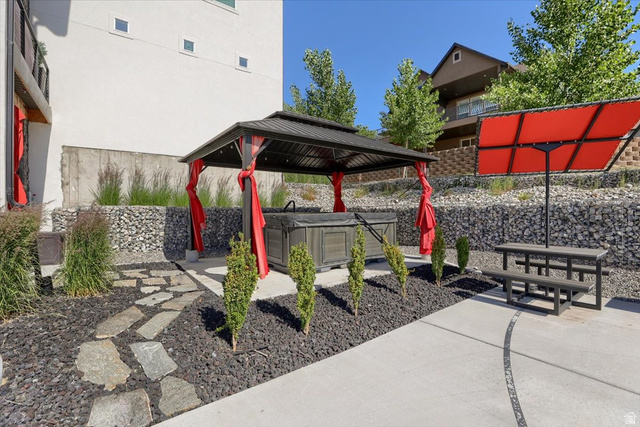 828 South Deer Road Tooele, UT 84074 - Photo 40 of 51 Outdoor patio featuring a covered hot tub, flagstone path, and a gabion wall
