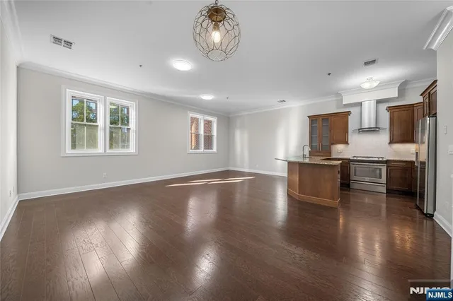 a large kitchen with kitchen island a sink dishwasher a stove and a refrigerator with wooden floor