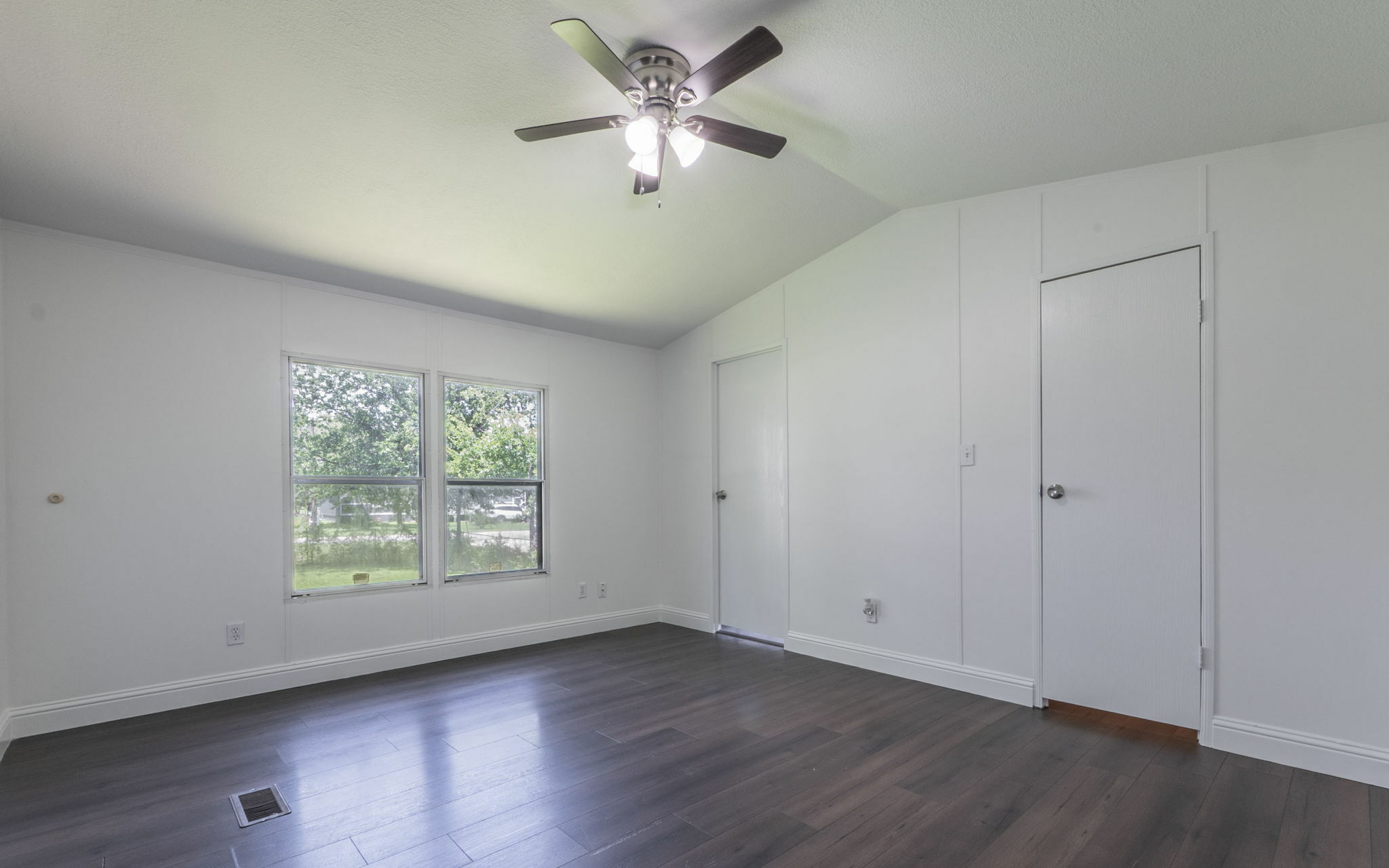 178 Quail Ridge Drive Kyle, TX 78640 - Photo 8 of 18 an empty room with wooden floor chandelier fan and windows