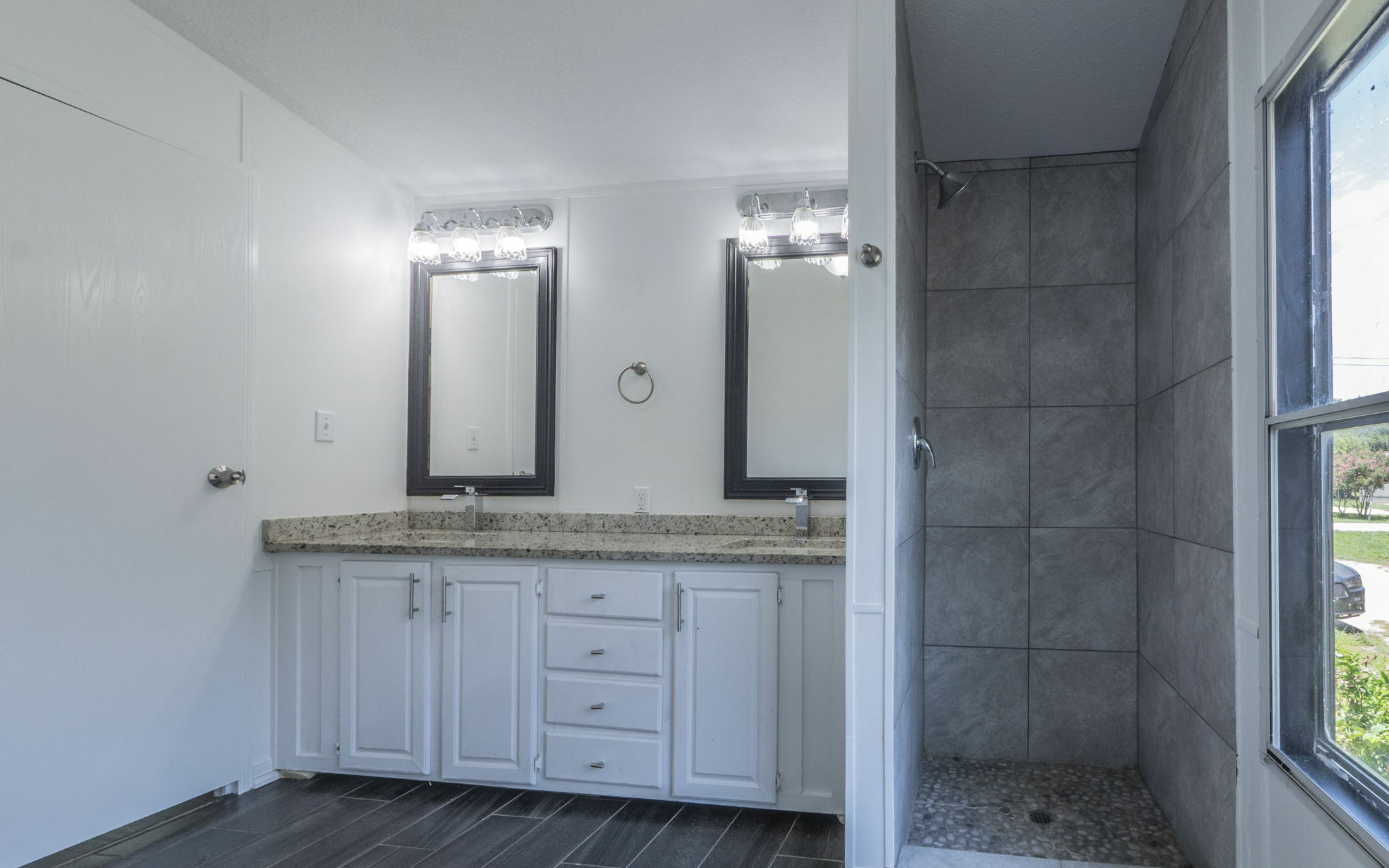178 Quail Ridge Drive Kyle, TX 78640 - Photo 9 of 18 a bathroom with a granite countertop sink a mirror and a shower