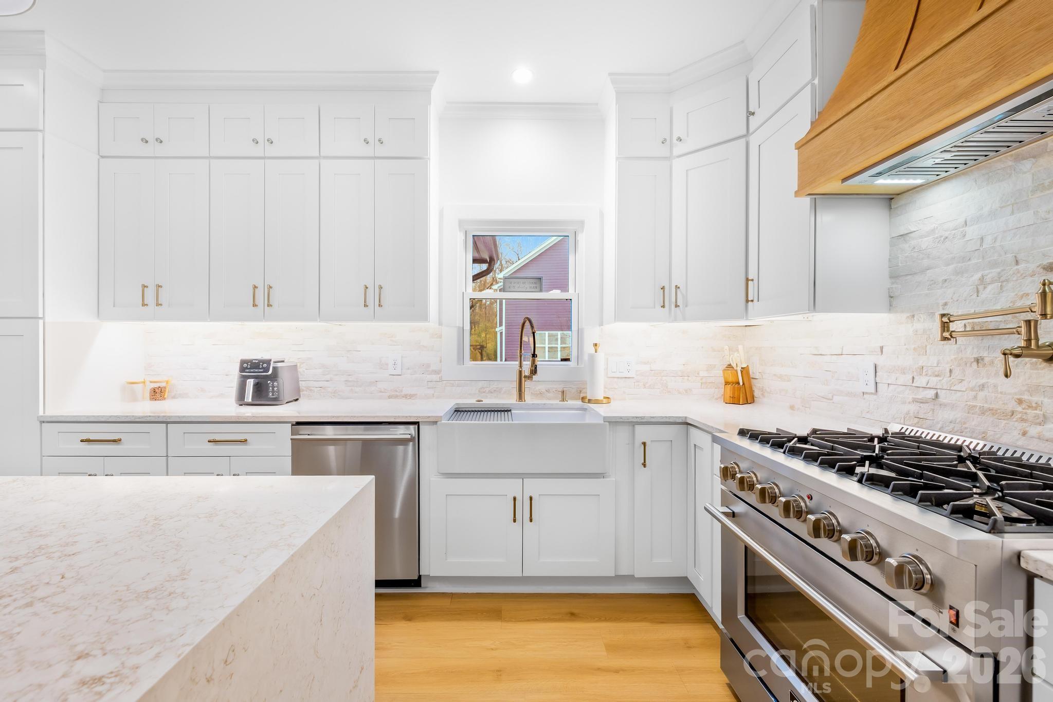 18441 Davidson-Concord Road Davidson, NC 28036 - Photo 11 of 36 a kitchen with stainless steel appliances a stove a sink and white cabinets