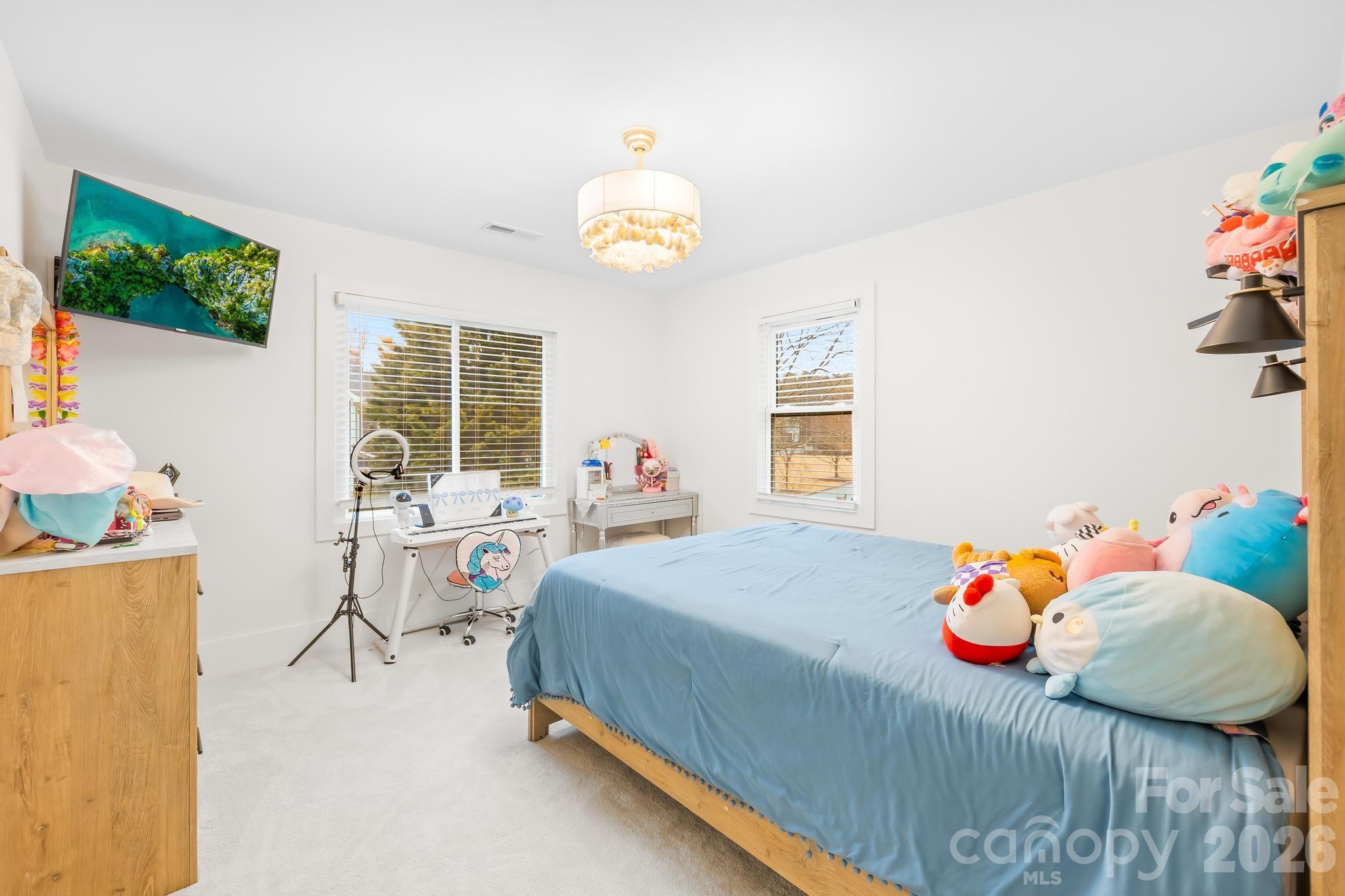 18441 Davidson-Concord Road Davidson, NC 28036 - Photo 22 of 36 a bedroom with a bed and a chandelier