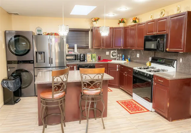 a kitchen with stainless steel appliances granite countertop a stove top oven a sink dishwasher and cabinets with wooden floor