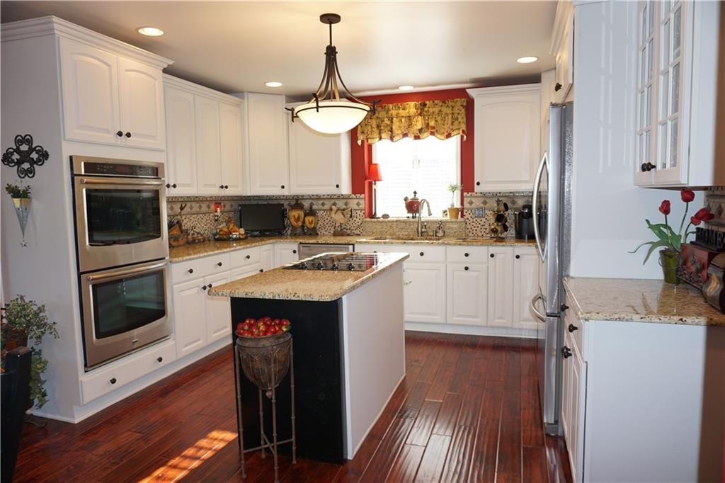 1011 Timber Ridge Court Harrison City, PA 15636 - Photo 8 of 25 Timeless white kitchen with granite countertops and custom back splash. Stainless Steel appliances complete the kitchen offering convection double wall oven, french door refrigerator, dishwasher and glass cook top.