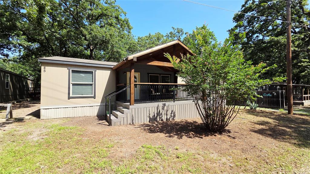 45 Bravo Road Pottsboro, TX 75076 - Photo 6 of 40 Single-story residence featuring a covered front porch with dark wood posts and a metal railing