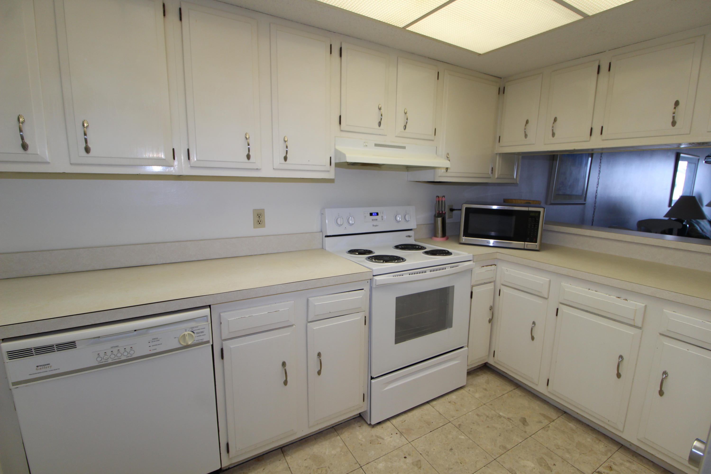 909 Santa Rosa Boulevard, Unit 548 Fort Walton Beach, FL 32548 - Photo 7 of 22 a kitchen with white cabinets and white appliances