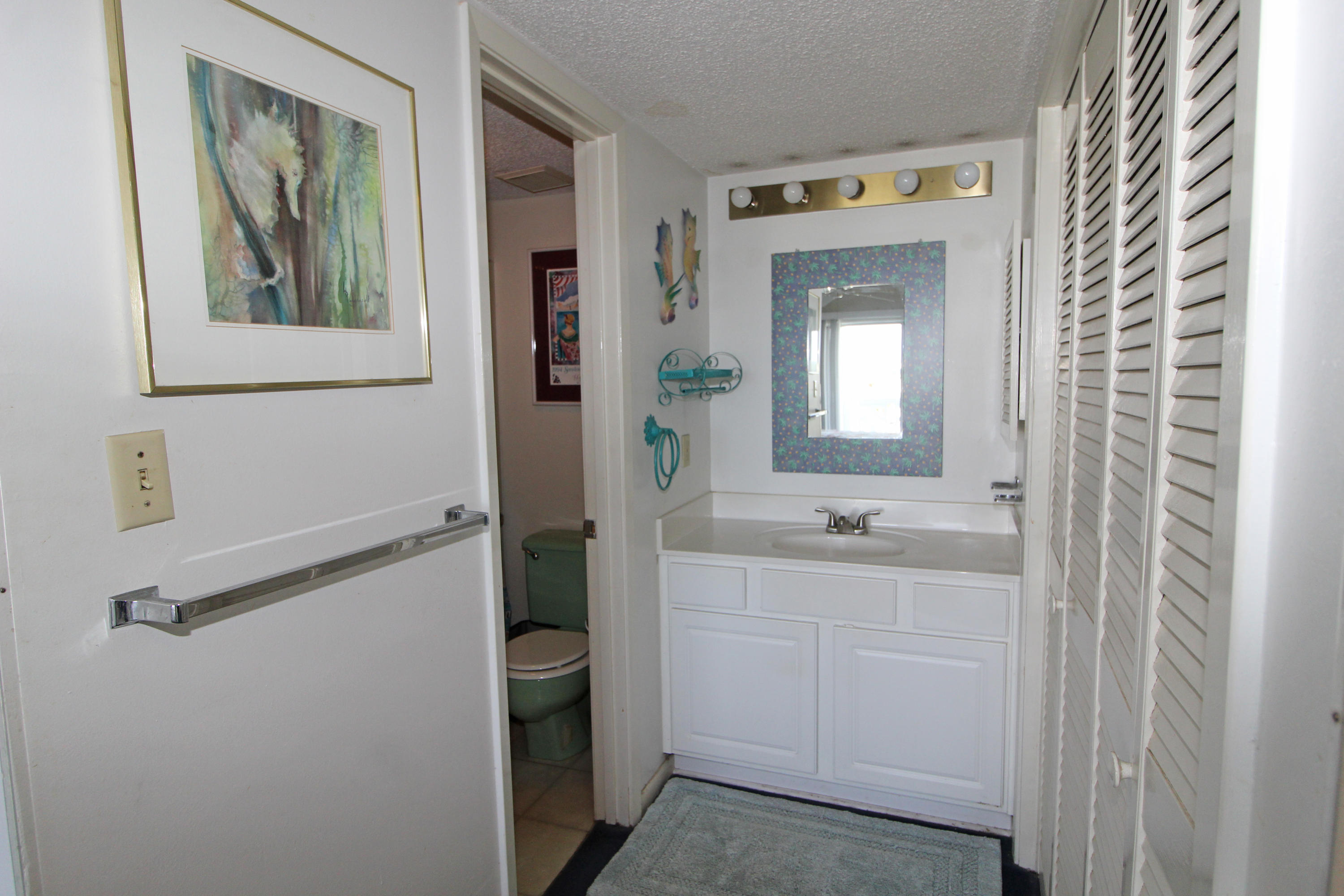 909 Santa Rosa Boulevard, Unit 548 Fort Walton Beach, FL 32548 - Photo 10 of 22 a bathroom with a sink and mirror with toilet