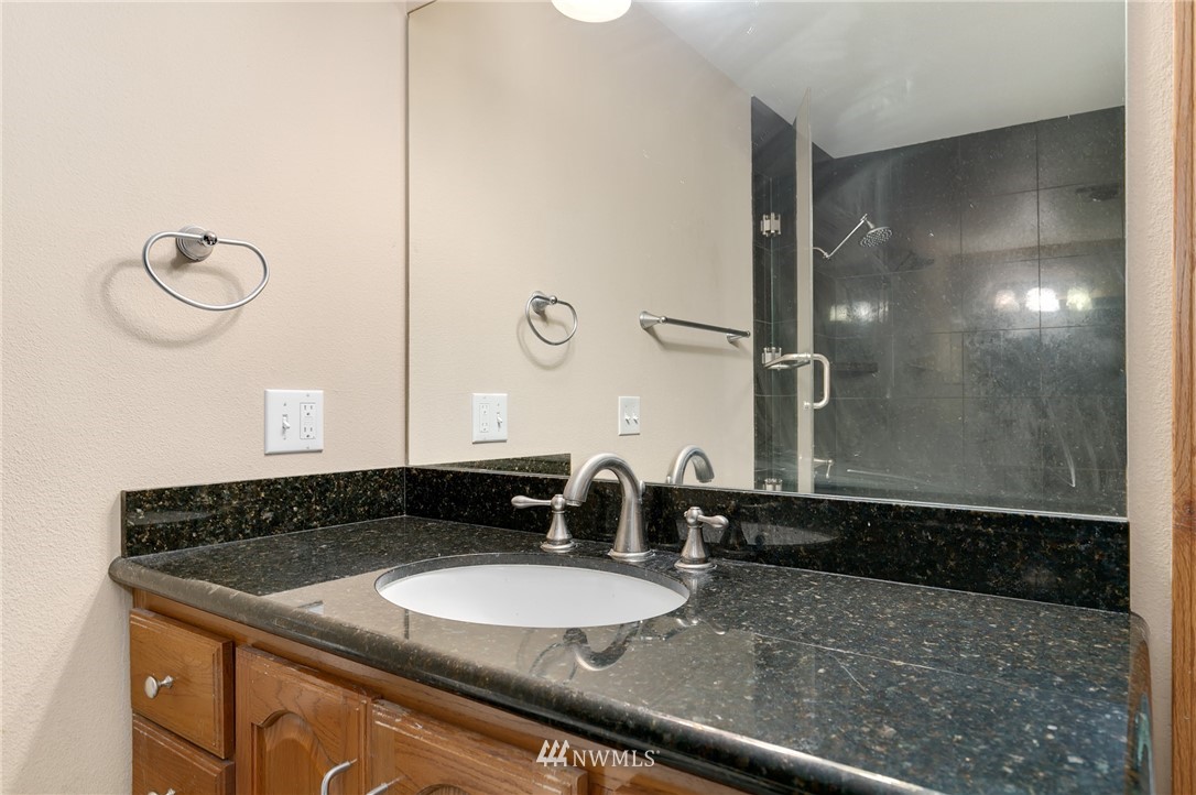 24303 23rd Avenue West Bothell, WA 98021 - Photo 14 of 25 a bathroom with a granite countertop sink a mirror and shower
