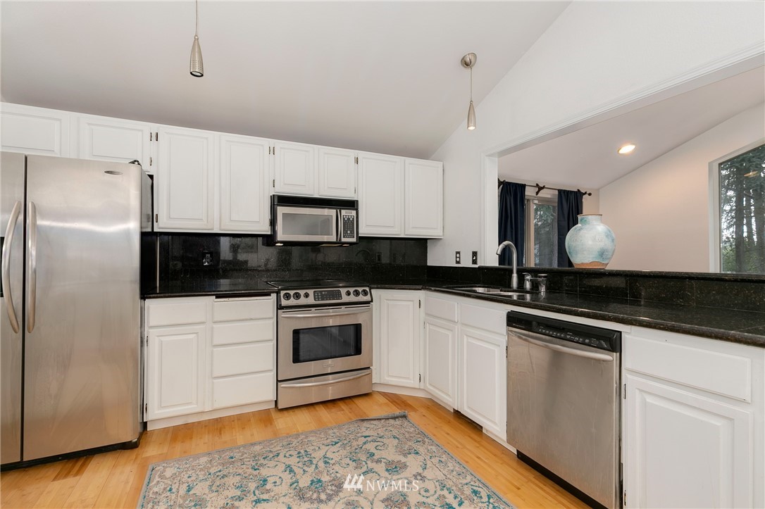 24303 23rd Avenue West Bothell, WA 98021 - Photo 3 of 25 a kitchen with granite countertop a sink stainless steel appliances and cabinets