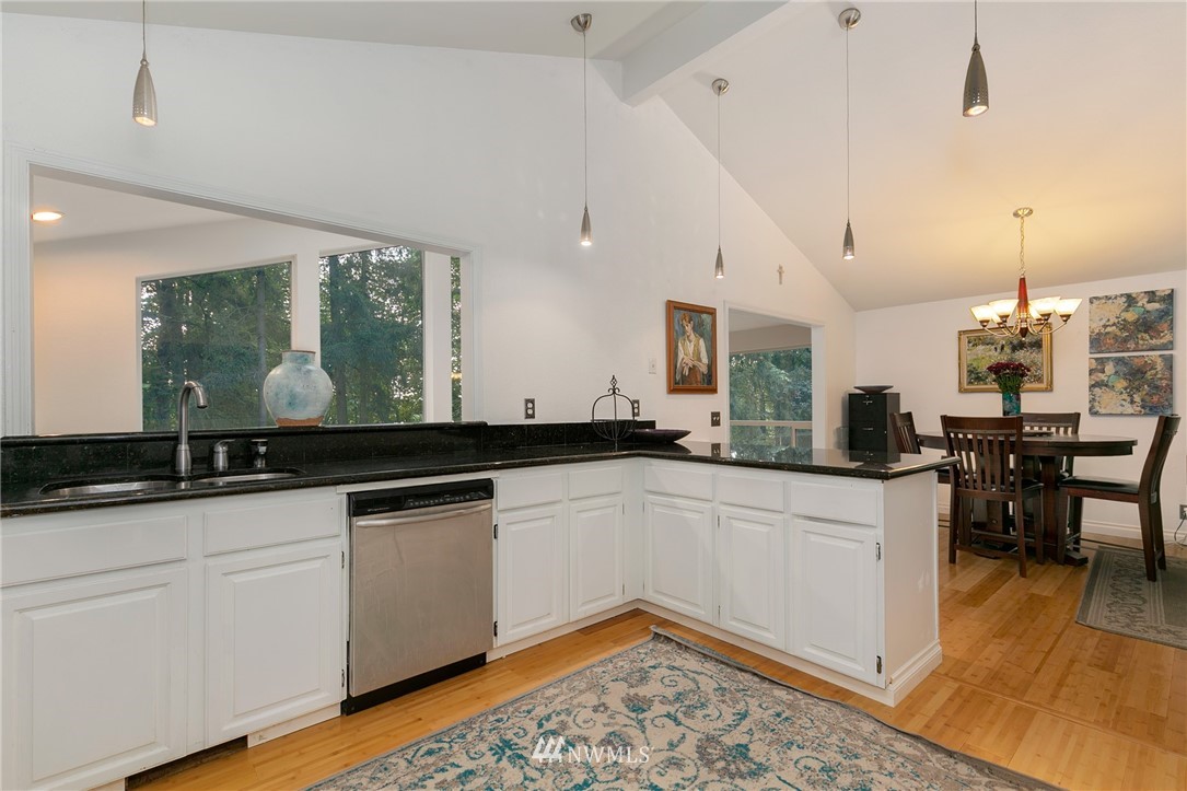 24303 23rd Avenue West Bothell, WA 98021 - Photo 4 of 25 a large white kitchen with granite countertop a sink and dishwasher a stove with wooden floor