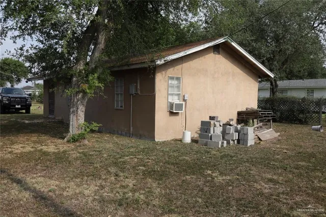a view of a house with backyard and trees