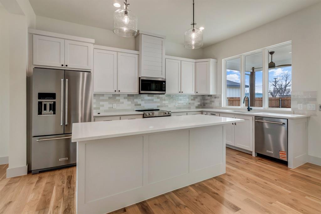 205 West 7th Street Justin, TX 76247 - Photo 13 of 35 a kitchen with stainless steel appliances a refrigerator sink and microwave