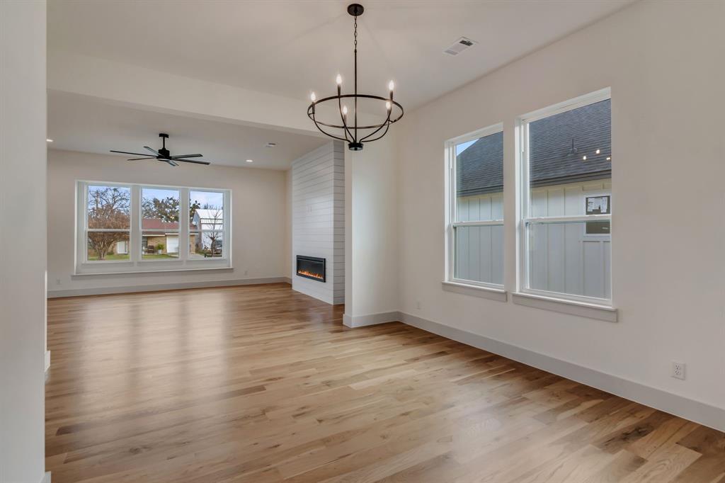 205 West 7th Street Justin, TX 76247 - Photo 17 of 35 a view of an empty room with a window and wooden floor
