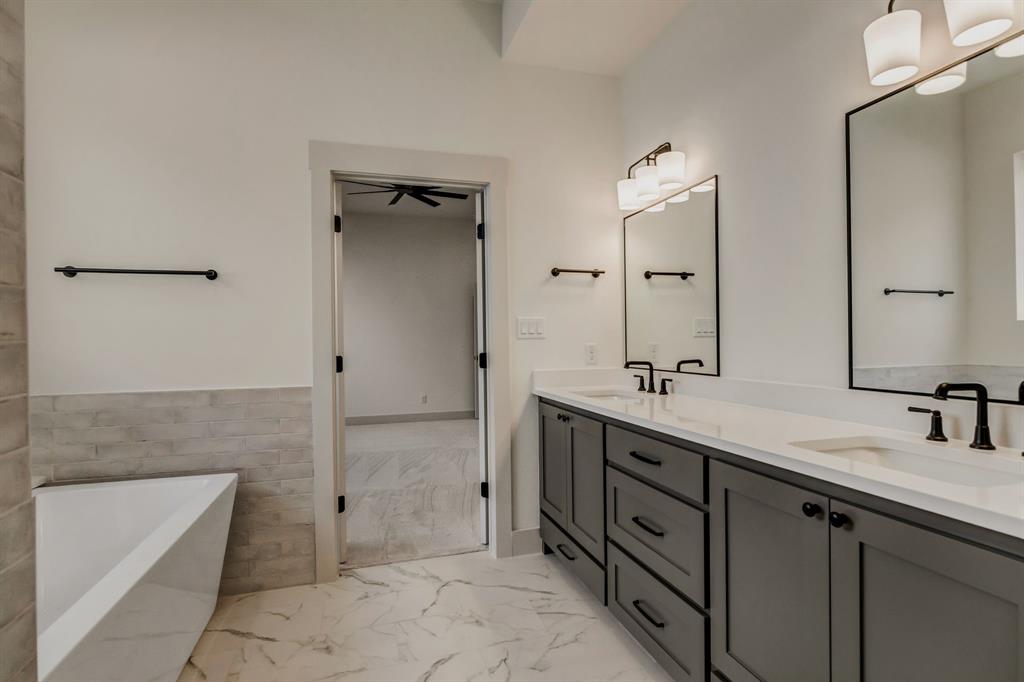 205 West 7th Street Justin, TX 76247 - Photo 21 of 35 a bathroom with a double vanity sink and mirror
