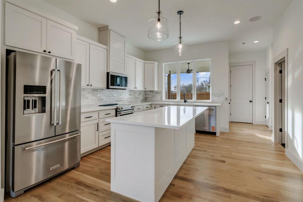 205 West 7th Street Justin, TX 76247 - Photo 7 of 35 a kitchen with stainless steel appliances granite countertop a refrigerator a stove a sink and a refrigerator