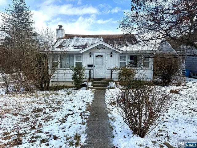 a view of a house with a yard and large tree