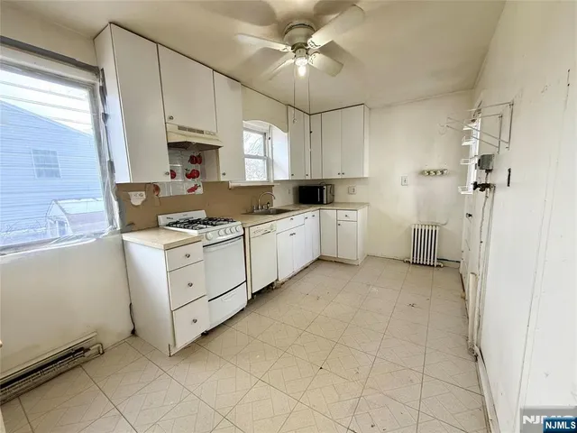 a kitchen with white cabinets and white appliances