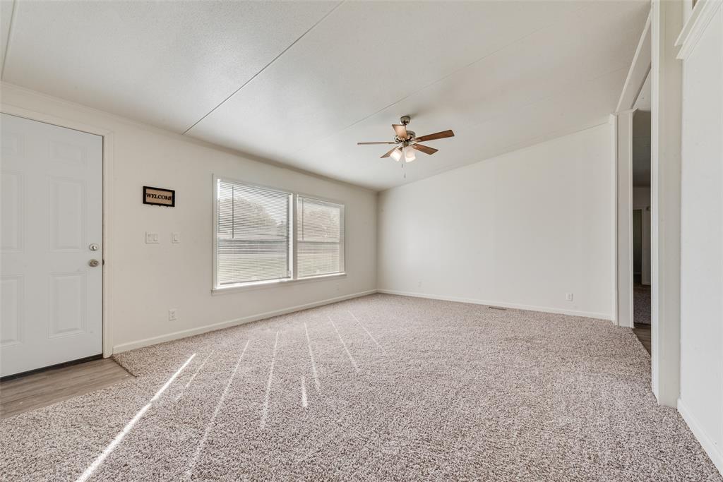 817 Kaufman Street Rosser, TX 75158 - Photo 5 of 29 Unfurnished room featuring light carpet, a ceiling fan, and lofted ceiling
