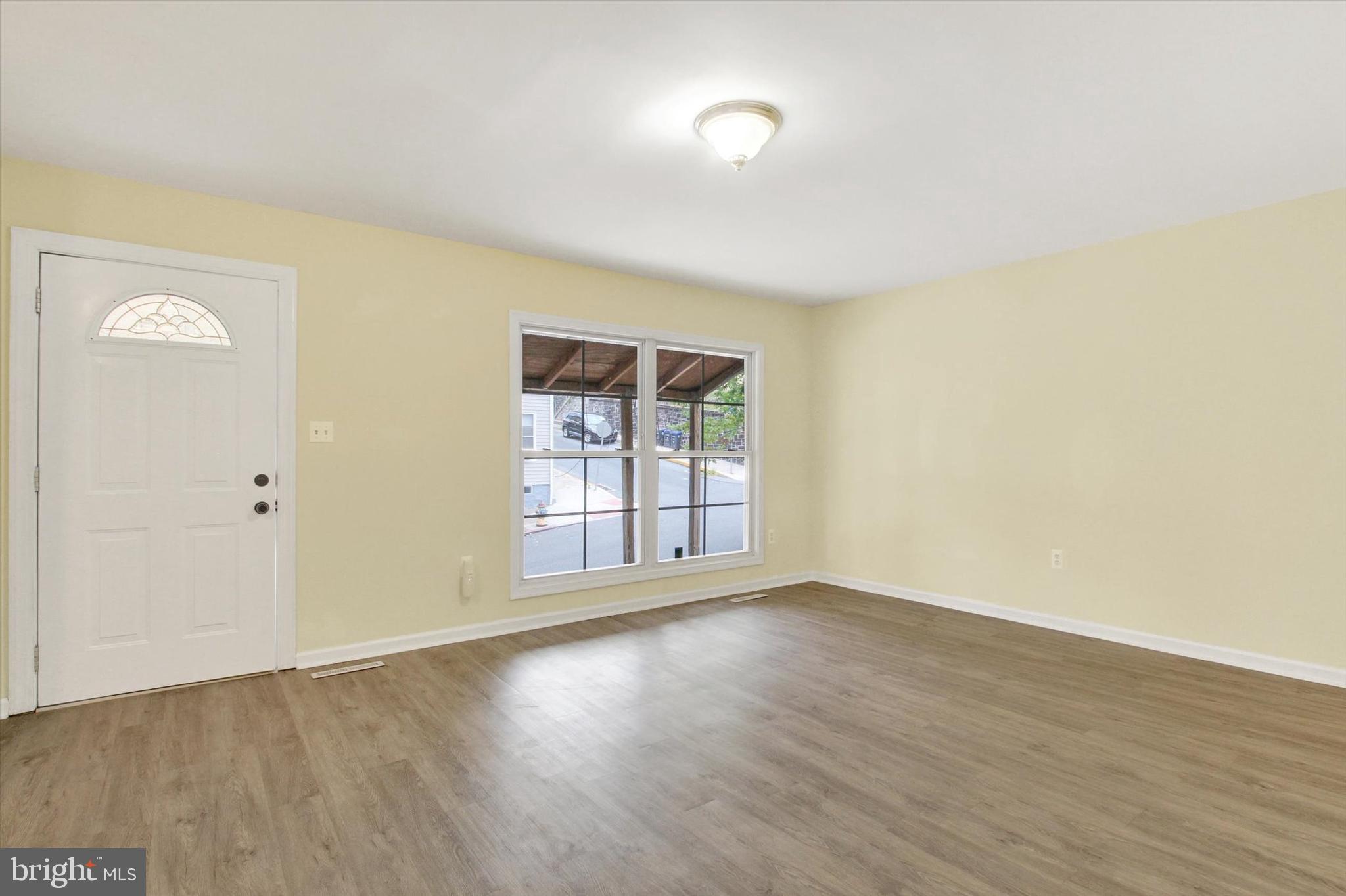 108 Walnut Street Steelton, PA 17113 - Photo 2 of 26 an empty room with wooden floor and windows