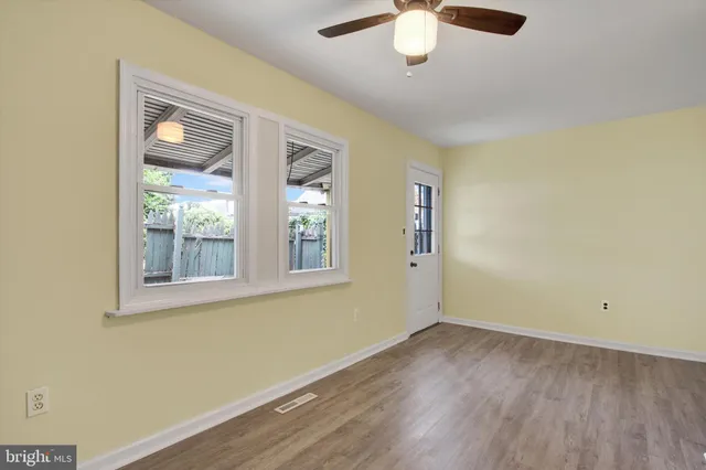 an empty room with a window and wooden floor