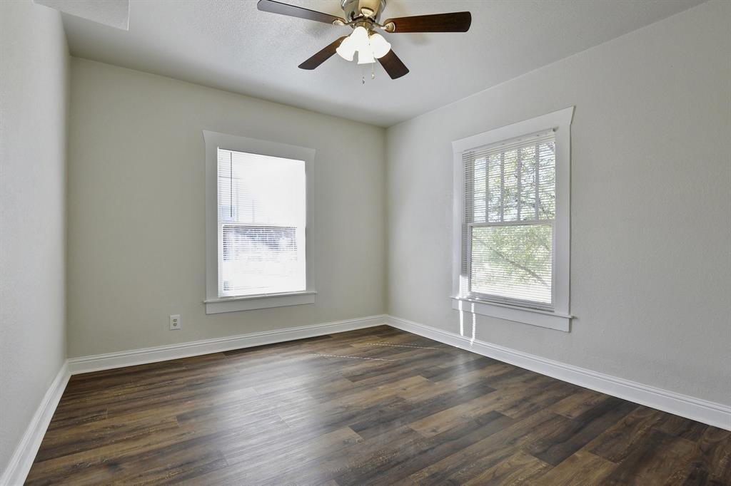1115 South Rusk Avenue Denison, TX 75020 - Photo 18 of 21 a view of an empty room with wooden floor and a window