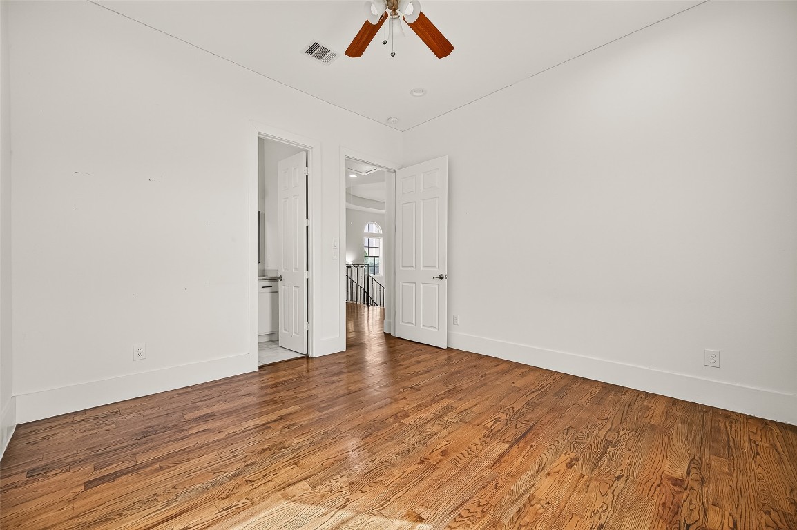 7915 Kirk Road Rosenberg, TX 77471 - Photo 19 of 28 Bright, airy room with warm hardwood floors, neutral walls, and recessed lighting. Features two doors and an open railing overlooking a stairwell.