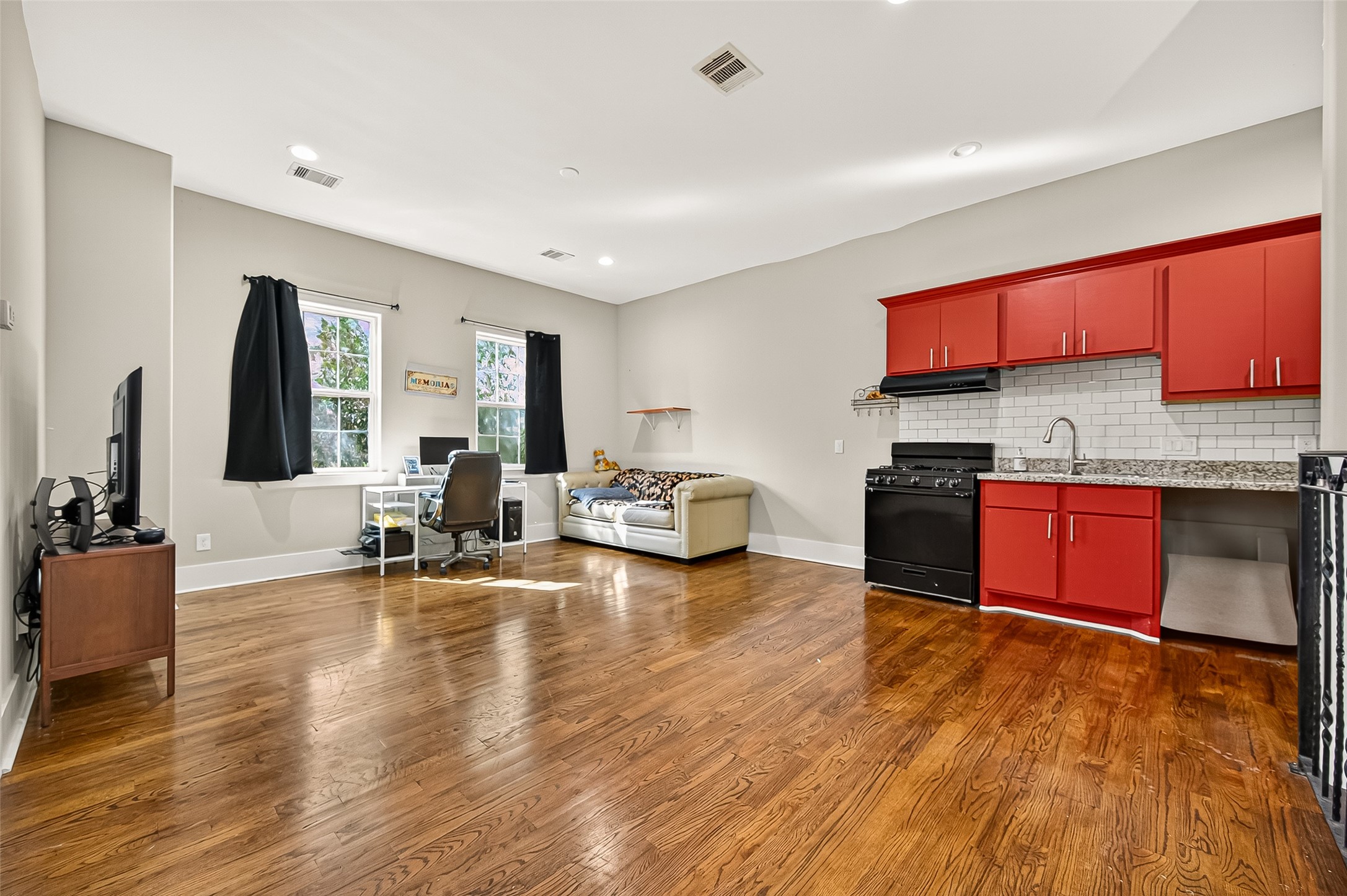 7915 Kirk Road Rosenberg, TX 77471 - Photo 27 of 28 This bathroom features a shower with a floral curtain, marble-patterned tile, a vanity with a red cabinet, and a large gold-framed mirror. There's also a shelving unit for additional storage.