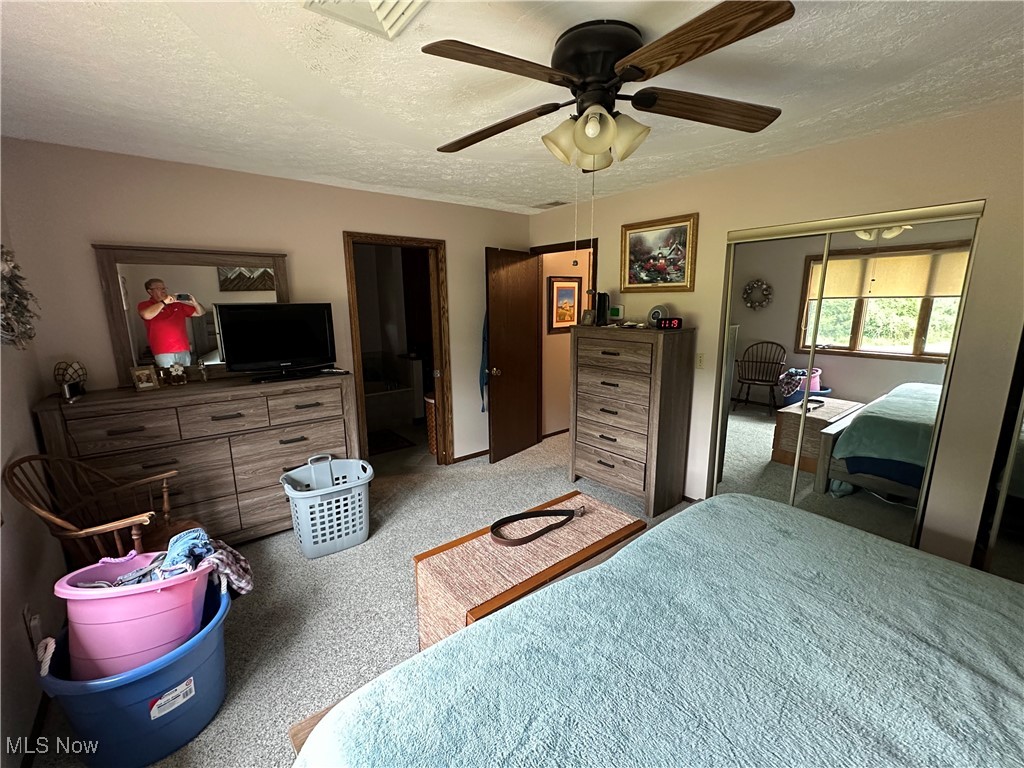 354 Big Bass Road Willard, OH 44890 - Photo 19 of 29 Bedroom with light carpet, a textured ceiling, a closet, and ceiling fan