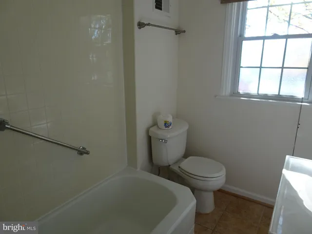 a white toilet sitting next to a window