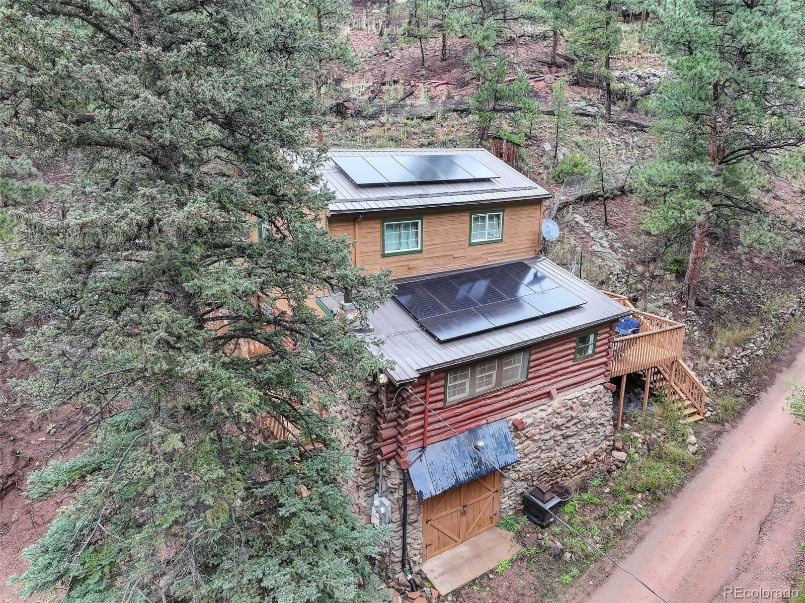 27403 Schuyler Gulch Road Pine, CO 80470 - Photo 16 of 40 a view of a wooden house with a tree