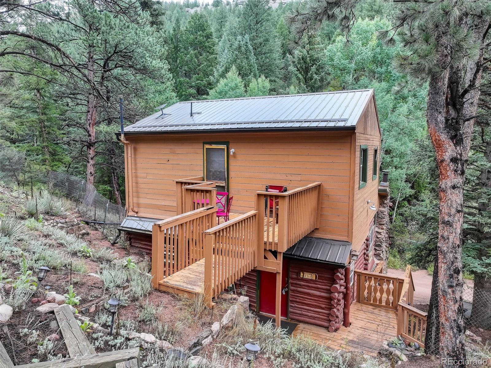 27403 Schuyler Gulch Road Pine, CO 80470 - Photo 20 of 40 a front view of a house with garden