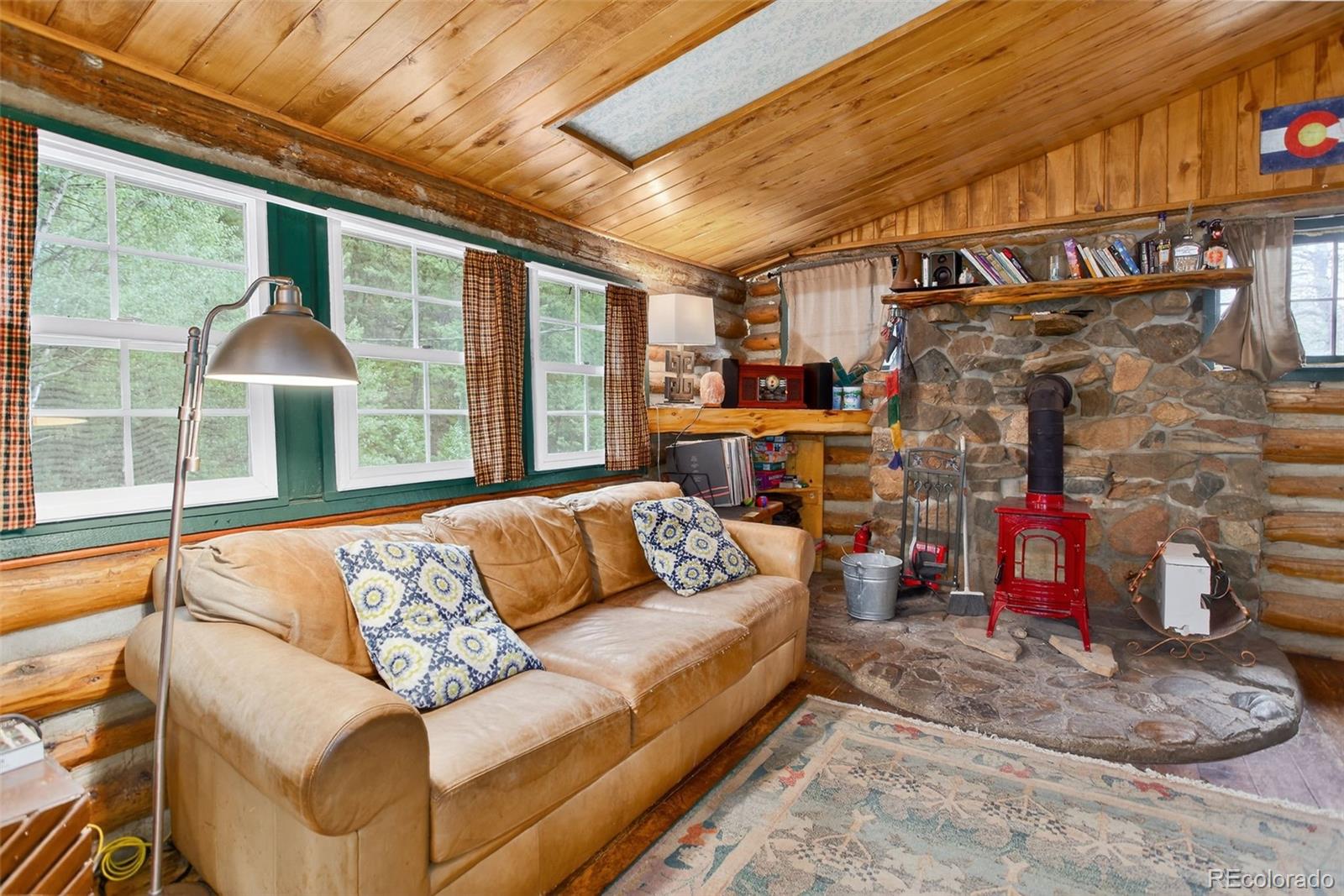 27403 Schuyler Gulch Road Pine, CO 80470 - Photo 26 of 40 a living room with couch and a fireplace