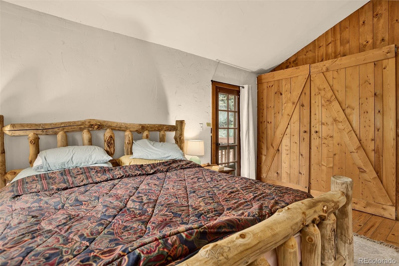 27403 Schuyler Gulch Road Pine, CO 80470 - Photo 27 of 40 a bedroom with a bed and wooden floor