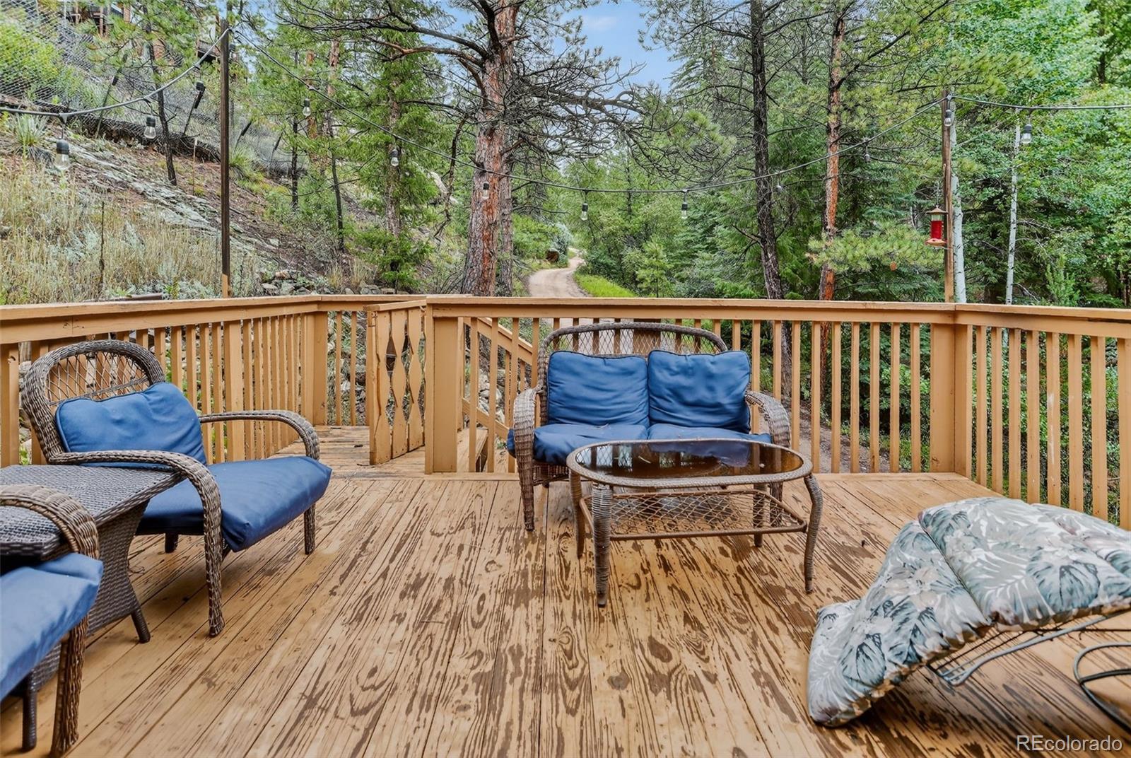 27403 Schuyler Gulch Road Pine, CO 80470 - Photo 31 of 40 a balcony with wooden floor table and chairs