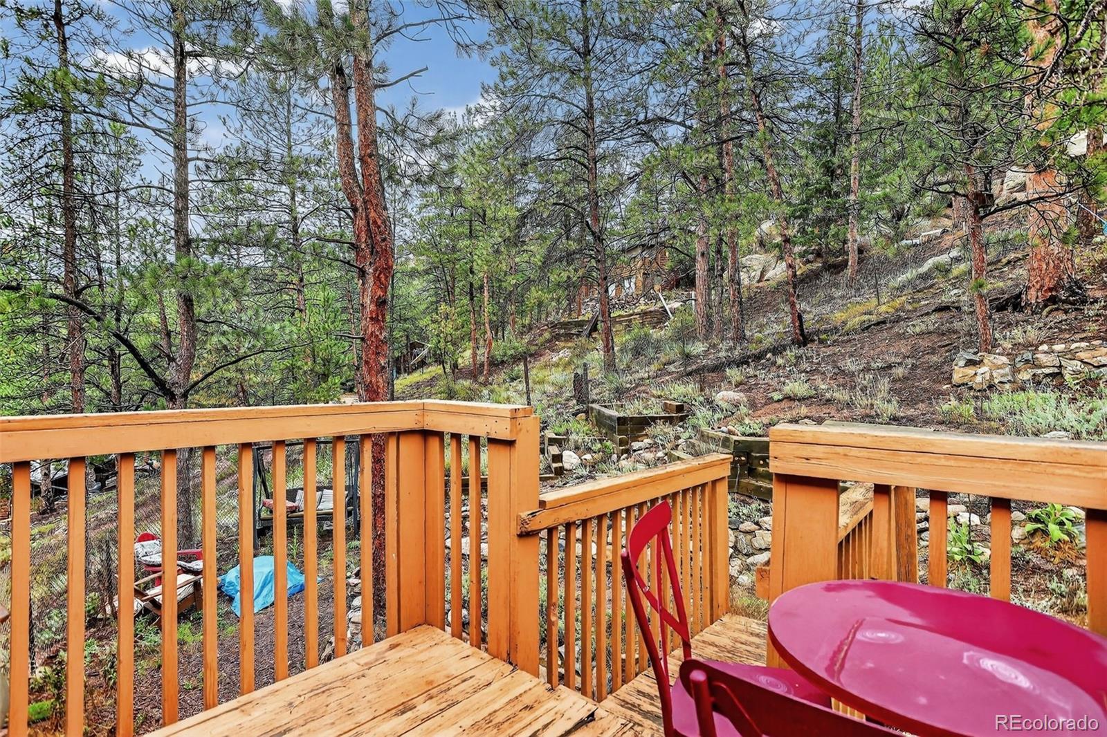 27403 Schuyler Gulch Road Pine, CO 80470 - Photo 32 of 40 a view of a red and white house with wooden fence
