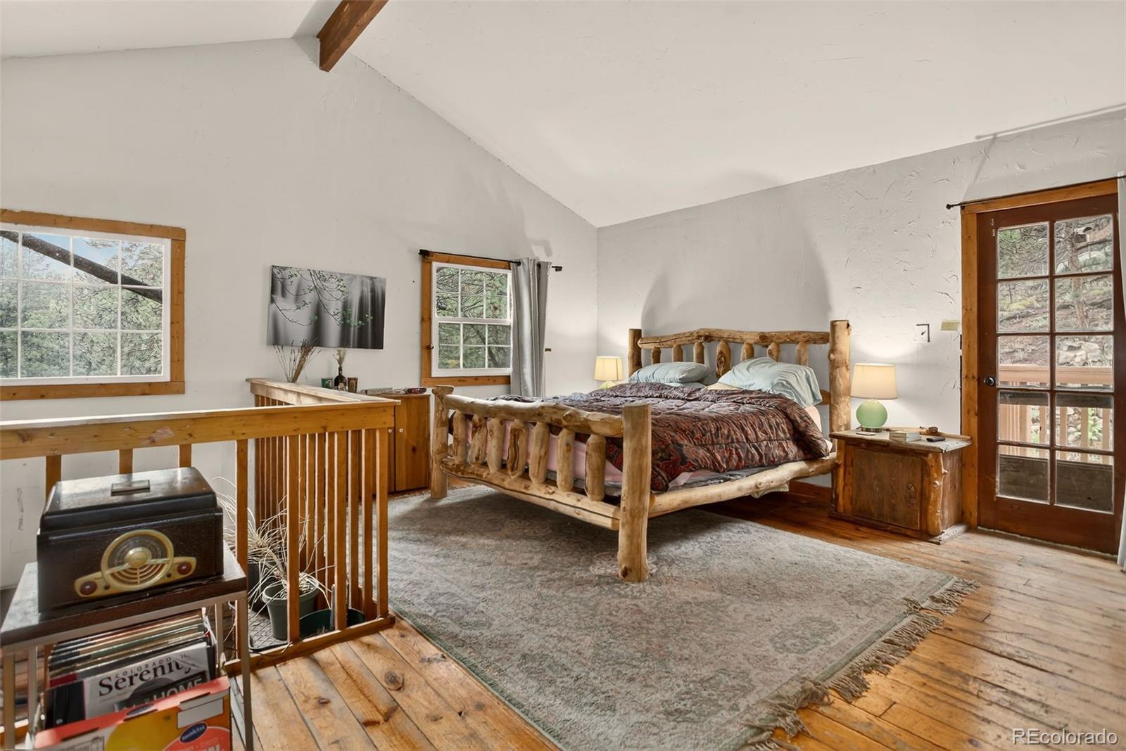 27403 Schuyler Gulch Road Pine, CO 80470 - Photo 6 of 40 a bedroom with a bed and wooden floor