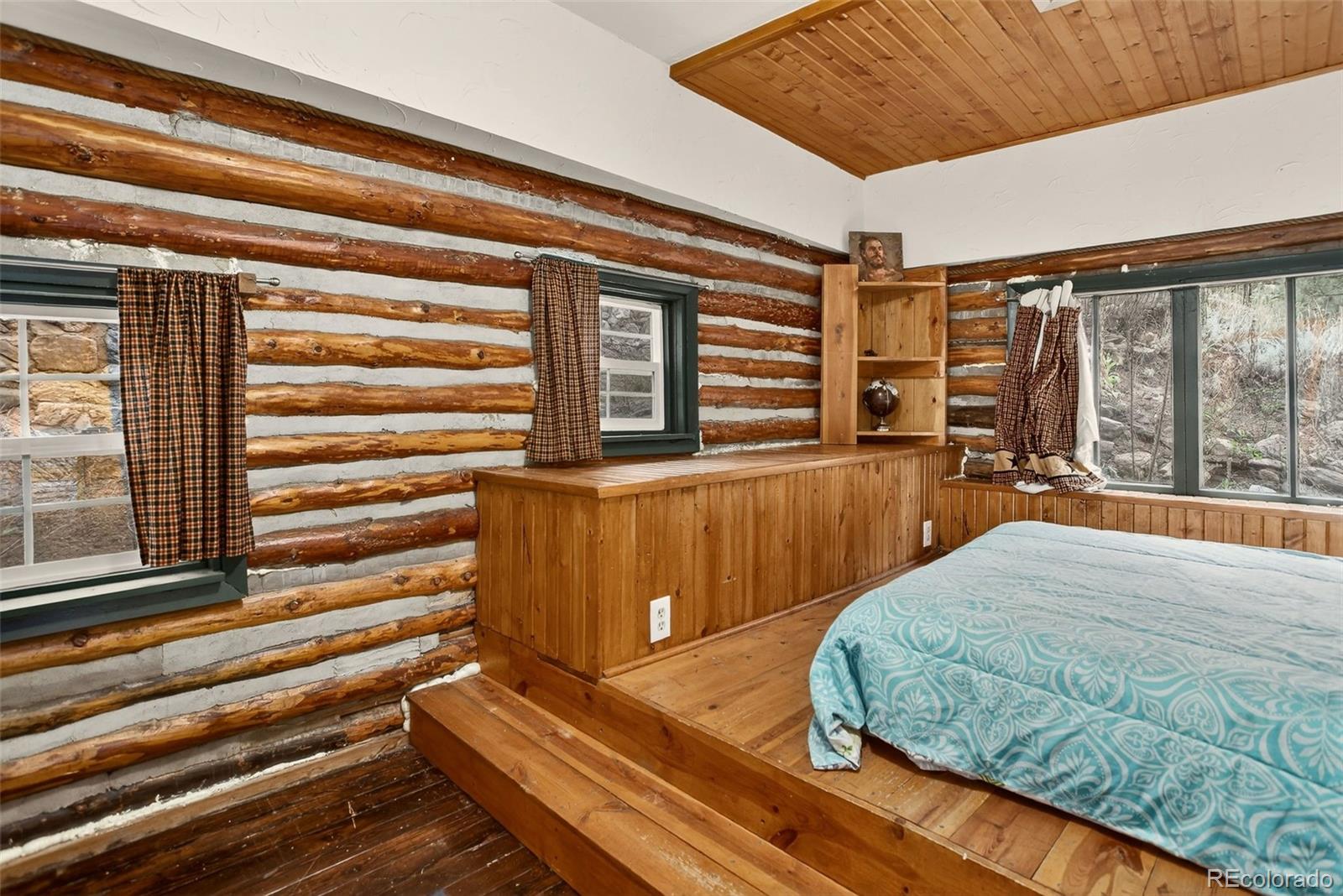 27403 Schuyler Gulch Road Pine, CO 80470 - Photo 7 of 40 a bedroom with a bed and wooden floor