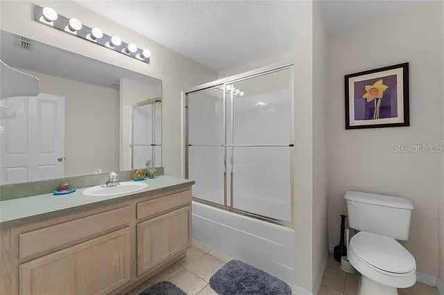 a spacious bathroom with a toilet sink and mirror